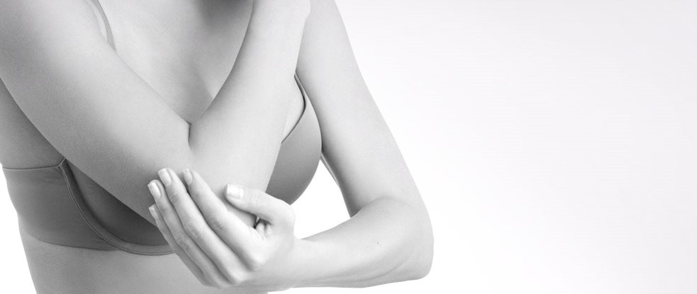 Woman wearing a bra touching her elbow